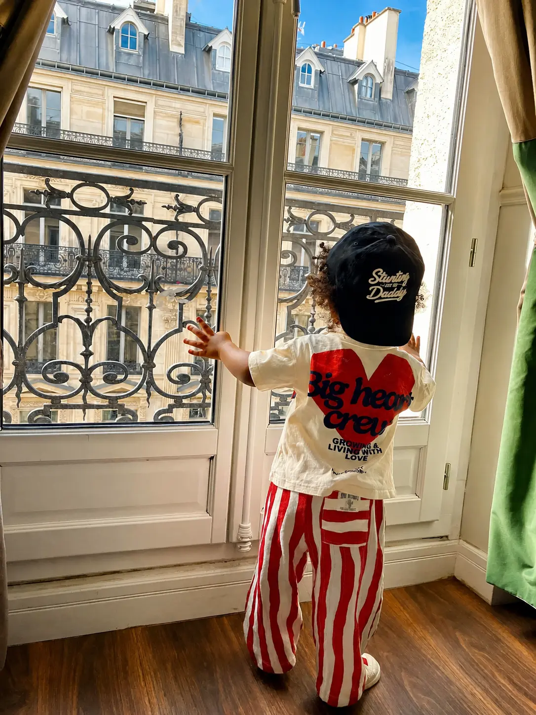 A child looking out over Paris from an apartment window